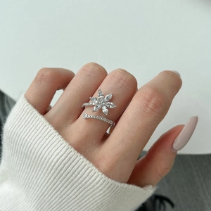 Detail of S925 sterling silver flower ring with marquise cut zircon stones on finger