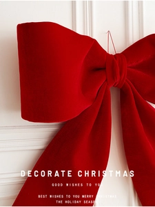 Detail of large red velvet Christmas bow featuring soft fabric texture for festive decor