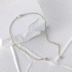 Detailed view of 925 sterling silver chain bracelet with a single white pearl and extender