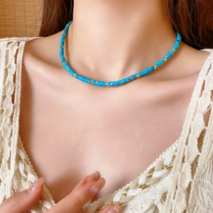 Close-up of vintage Shoushan stone necklace with blue round beads and gold metal spacers
