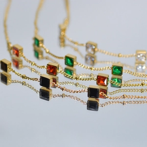 Elegant gold bracelet with square-cut emerald, ruby, black and clear zircon gemstones