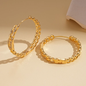 Detail of 18k gold plated chain hoop earring with micro-set cubic zirconia on warm stone