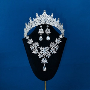 Close-up of bridal jewelry set with crystal crown, necklace and earrings on dark background