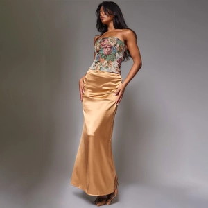 Damen Set mit besticktem Bustier-Oberteil und goldenem Satin-Maxirock am Fashion-Model