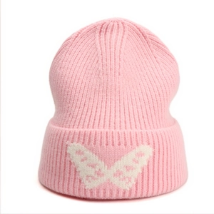 Close-up of pink ribbed knit beanie with white butterfly jacquard pattern details