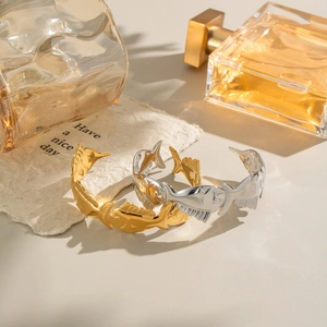 Fish-shaped open bangle in gold and silver finish with elegant minimalist hollow design
