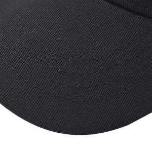 Dettaglio macro della visiera del cappellino in twill nero con cuciture di rinforzo parallele