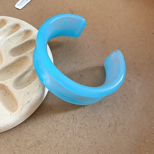 Sky blue irregular acrylic cuff bracelet with white marble effect and open design