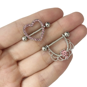 Détail de bijoux de téton argentés avec cœur et couronne en cristaux roses sur la main