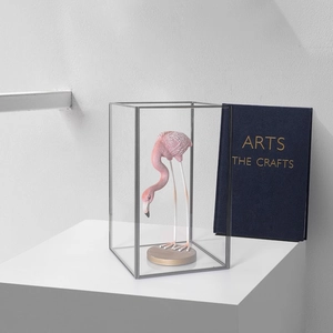 Modern gold metal and glass display box with pink flamingo sculpture for home decor