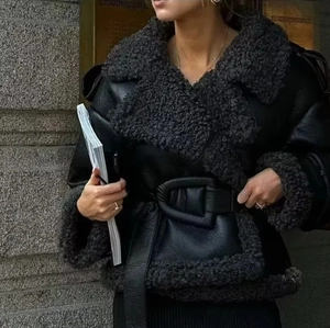 Detail of black leather aviator jacket featuring plush faux fur collar and waist belt