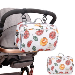 Wasserdichte Kinderwagentasche mit Grapefruit-Print hängend am Griff des Kinderwagens
