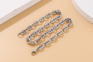 Macro view of silver pig nose chain necklace links with a polished metallic finish