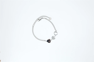 Detailed close-up of a silver heart charm bracelet featuring solid and crystal heart pendants
