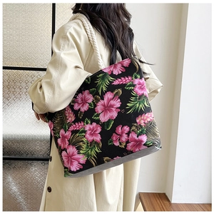 Detail of tropical floral canvas tote with vibrant hibiscus print and rustic rope straps