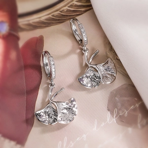 Elegant silver ginkgo leaf drop earrings with sparkling zircon stones in a macro view