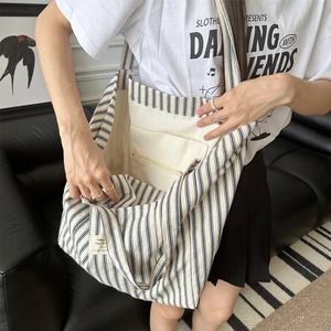 Detail view of large canvas tote bag with blue stripes and interior zipper pocket