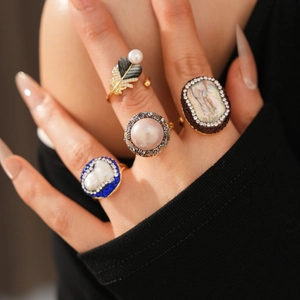 Detailed view of vintage gold-plated rings with baroque pearls and geometric crystals