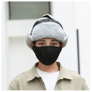 Detailed close-up of a grey faux fur winter trapper hat and black face mask on a male model