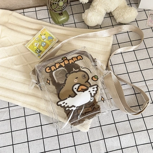 Detail of transparent PVC crossbody bag with plush Capybara inner and cartoon graphics
