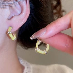 Detail showing yellow enamel bamboo hoop earrings with sparkling rhinestones on model