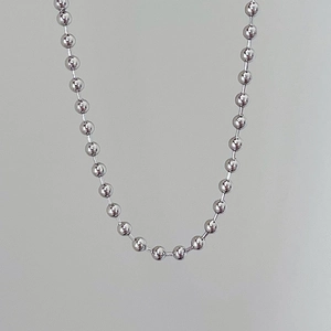 Close-up of industrial silver beaded ball chain necklace showing polished metal texture