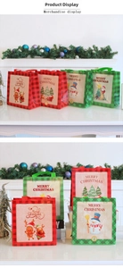 Close-up of festive Christmas non-woven gift bags with Santa and reindeer illustrations