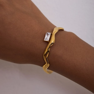 Close-up of wavy 18K gold-plated stainless steel bracelet with square zircon gemstone