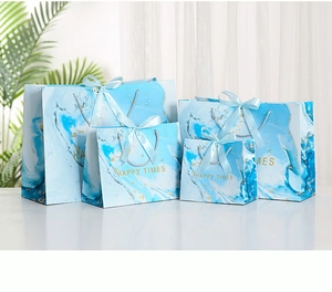 Detail showing four sizes of blue marble gift bags with gold speckles and ribbon handles