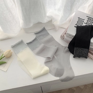 Close-up of ballet-style sheer crew socks in four colors with stylish rolled cuffs