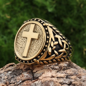 Macro shot of vintage bronze cross ring with Celtic knot patterns on a natural wood surface