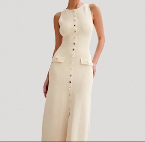 Détail d'une robe longue en maille avoine avec boutons dorés et texture côtelée fine