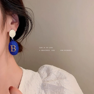 Minimalist Klein blue drop earrings with cream stud and gold letter B pendant