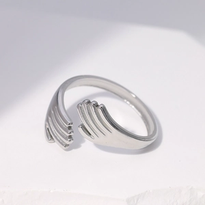 Adjustable silver hugging hands ring made of stainless steel on white stone surface