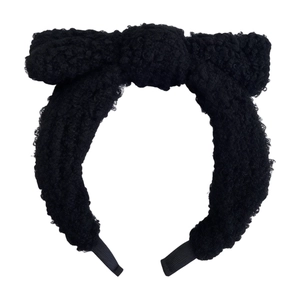 Fashionable black faux fur headband with plush bow design for a high top hairstyle look