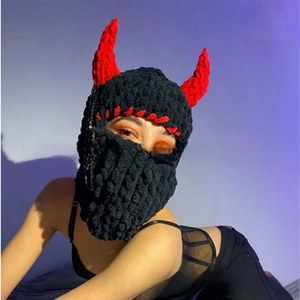Detail of knitted devil horn balaclava with red accents and punk style metal chain