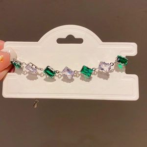 Close-up of luxury green and clear gemstone bracelet in silver French court style