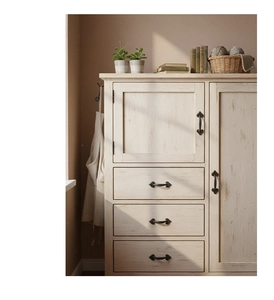 Detail of vintage cast iron handle on rustic white distressed wooden storage cabinet