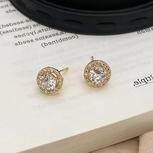 Detailed close-up of golden halo stud earrings featuring sparkling round cubic zirconia