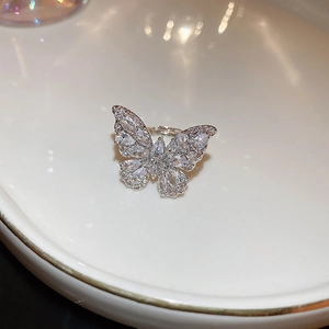 Dettaglio dell'anello a farfalla argento con zirconi su vassoio in ceramica