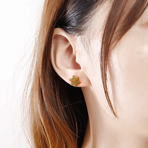Close-up of golden snowflake stud earring worn by a model for a festive Christmas look
