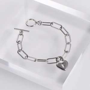 Silver stainless steel heart lock bracelet with OT toggle clasp on acrylic stand
