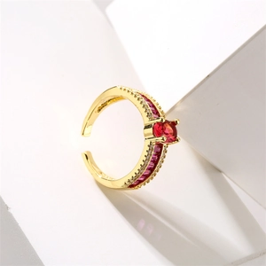Detail of gold evil eye ring featuring a red zircon main stone and adjustable band