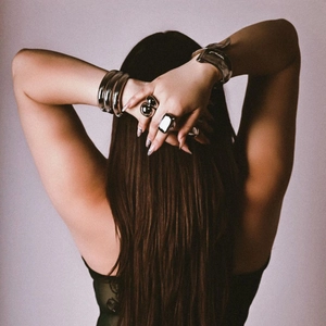 Fashionable stack of bold silver stainless steel bracelets and rings on a female model
