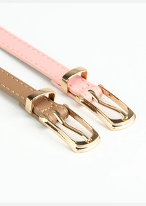 Detail of pink and khaki thin PU leather belts with gold metal pin buckles for dresses