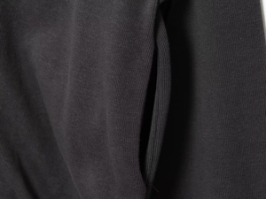 Detailed macro view of dark grey knitted fabric showing seamless pocket stitching quality