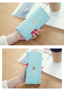 Close-up of light blue quilted leather wallet featuring a golden crown metal logo