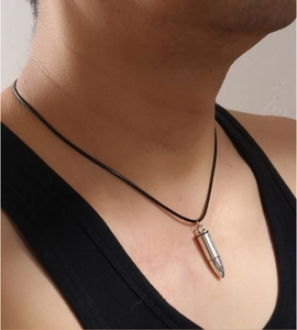 Close-up of men's bullet pendant necklace with silver finish and black leather cord