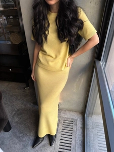 Detail of slim fit ginger yellow knit set featuring short sleeve top and maxi skirt