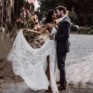 Abito da sposa sexy in pizzo bianco con spalline sottili e spacco alto all'aperto